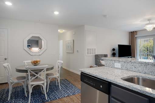 A kitchen with a table and chairs and a mirror on the wall.