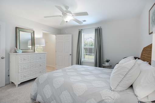 A bedroom with a bed, dresser, and mirror.