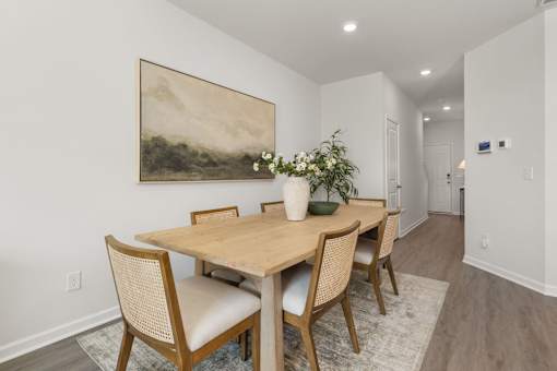 A dining room with a wooden table and chairs.