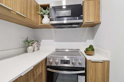 A modern kitchen with a stainless steel oven and wooden cabinets.