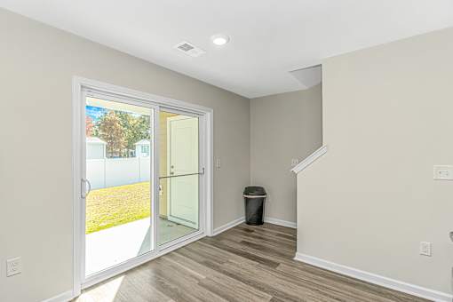 A room with a white door leading to a backyard.