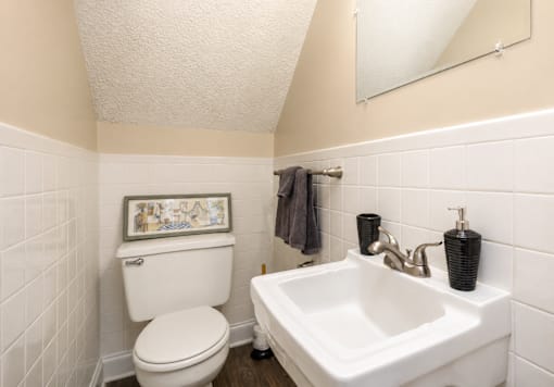 A white toilet and sink in a small bathroom.