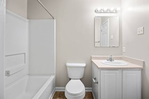 A white toilet sits next to a sink in a bathroom.