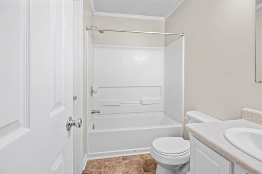 A white bathroom with a toilet, sink, and bathtub.