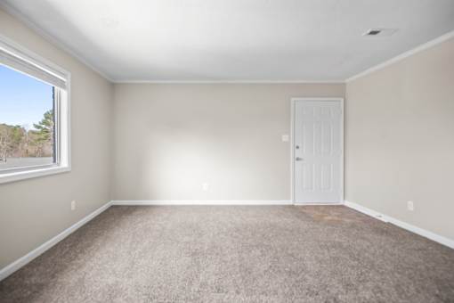A room with a carpeted floor and a white door.