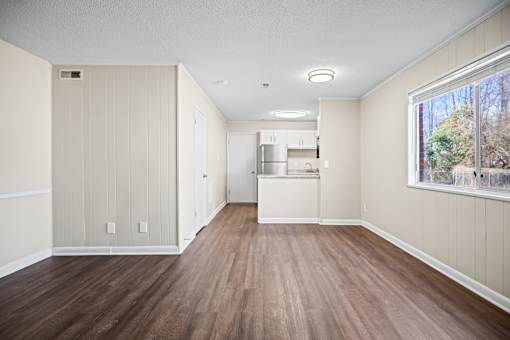 A kitchen area with wood flooring and white walls.