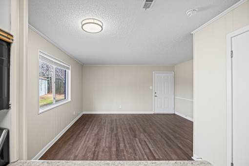 A room with a white ceiling and wooden flooring.