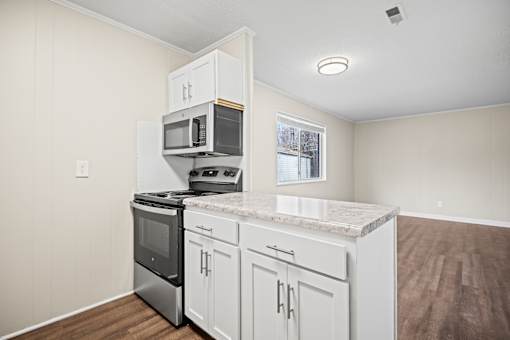 A kitchen with a granite countertop and white cabinets.