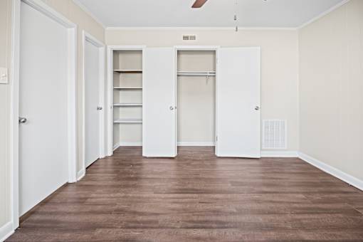 A room with white doors and a brown floor.