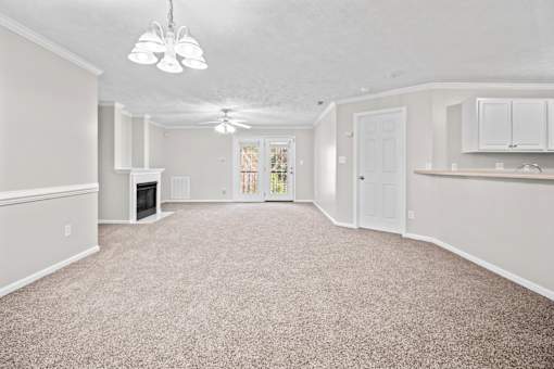 A spacious living room with a fireplace and a carpeted floor.
