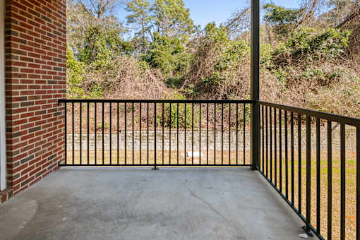 A black metal fence encloses a concrete patio.