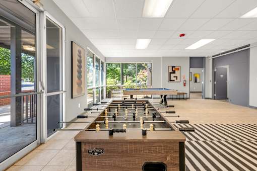 A room with a long table and chess pieces on it.