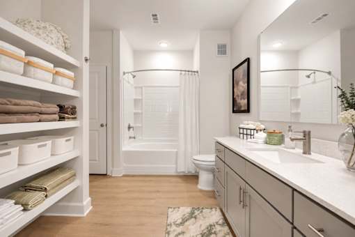 A bathroom with a white towel on the shelf.