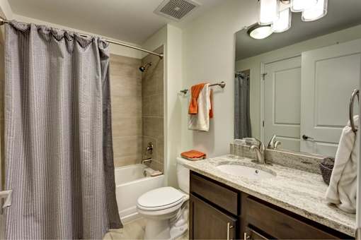A bathroom with a toilet, sink, and shower.