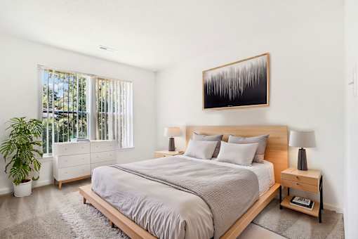 A bedroom with a large bed and a painting on the wall.