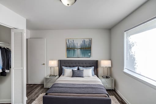 A bedroom with a large bed and a painting above it.