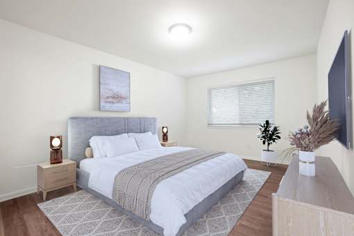 A bedroom with a large bed and a flat screen TV mounted on the wall.