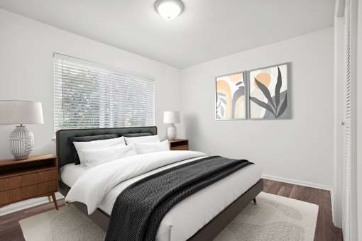 A bedroom with a large bed and two lamps.