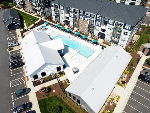 A large white building with a pool in front of it.