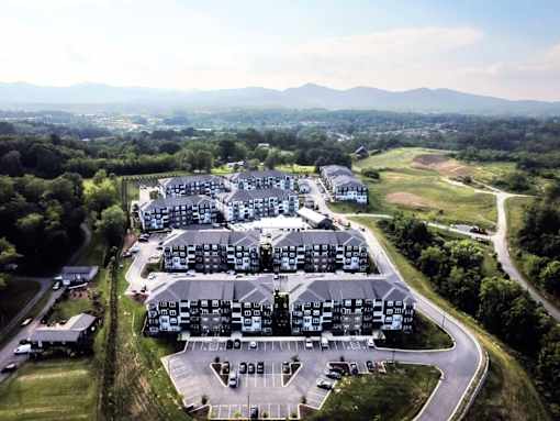 A large building complex with a parking lot in front.
