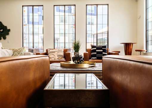 A living room with brown leather couches and a glass coffee table.