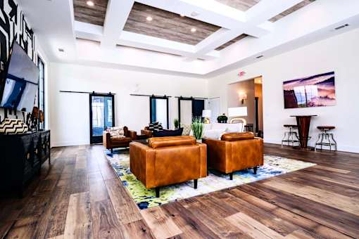 A living room with brown leather couches and a wooden floor.