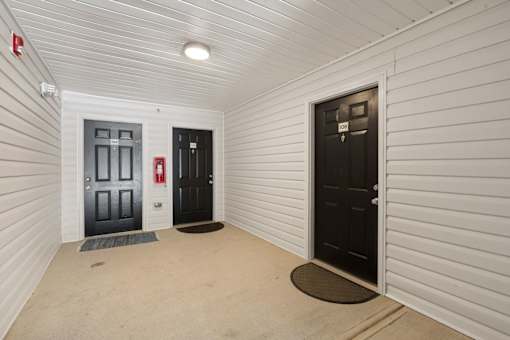 A hallway with two doors, one of which is open.