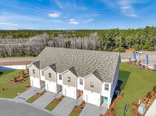 A row of houses with a forest in the background.