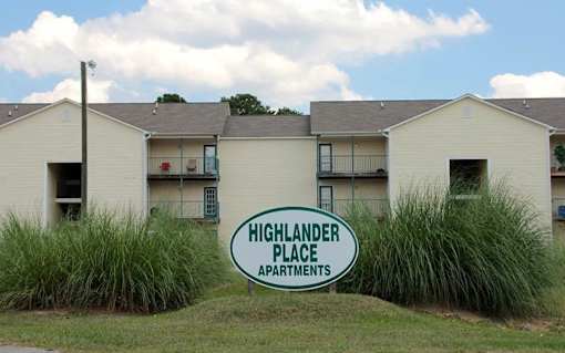 The sign in front of the building says Highlander Place Apartments.