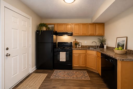 A kitchen with wooden cabinets and black appliances.