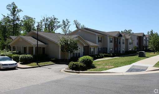 A white car is parked in front of a house.