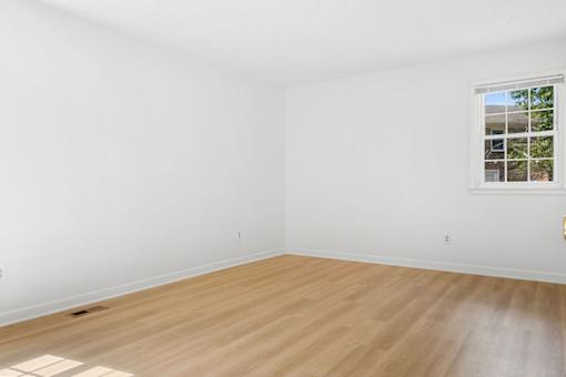 Empty room with wooden floor and white walls.