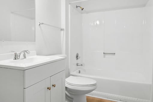 A white bathroom with a toilet, sink, and bathtub.
