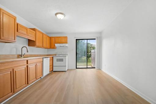 A kitchen with wooden cabinets and a white oven.