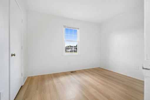 Empty room with wooden floor and a window.