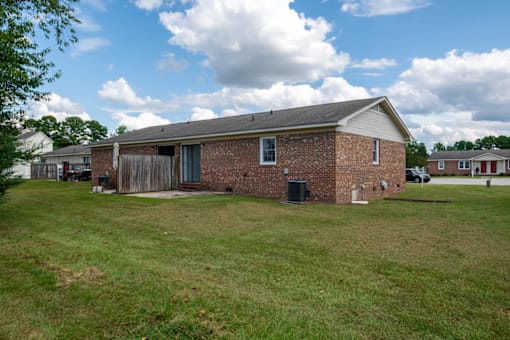 A brick house with a green lawn in front.