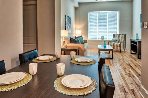 A dining room with a long table set for a meal.