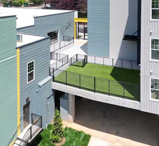 A green lawn is in front of a grey building.