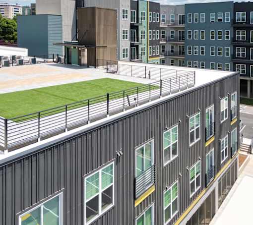 A building with a green roof and a balcony with a railing.