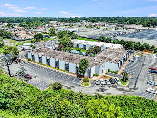 A large industrial building with a parking lot in front.