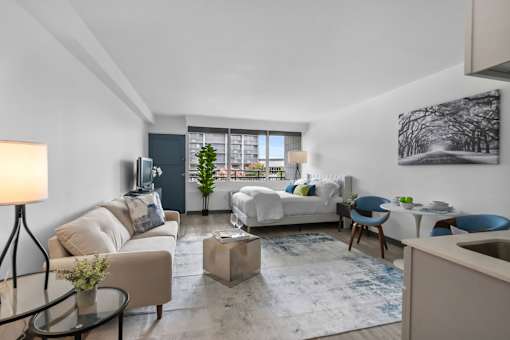 A living room with a white couch and a blue chair.