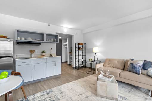 A modern kitchen with a dining table and a couch in the living room.