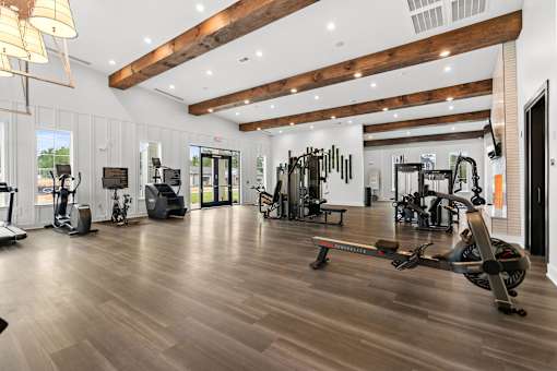 A gym with a variety of equipment including treadmills, weights, and exercise machines.