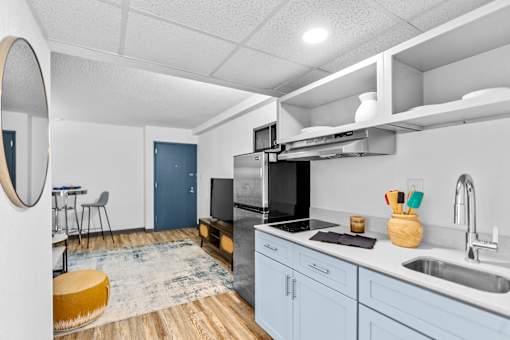 A modern kitchen with a blue cabinet and a wooden floor.