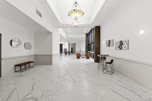 A long hallway with a marble floor and white walls.