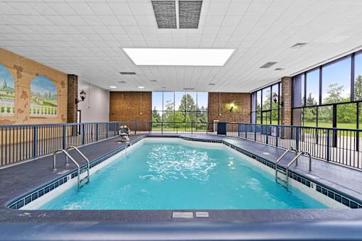 A large indoor swimming pool with a mural on the wall.