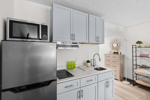A modern kitchen with a stainless steel refrigerator and white cabinets.