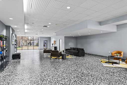 A spacious room with a grey floor and furniture.