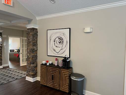 A hallway with a stone pillar and a framed picture on the wall.