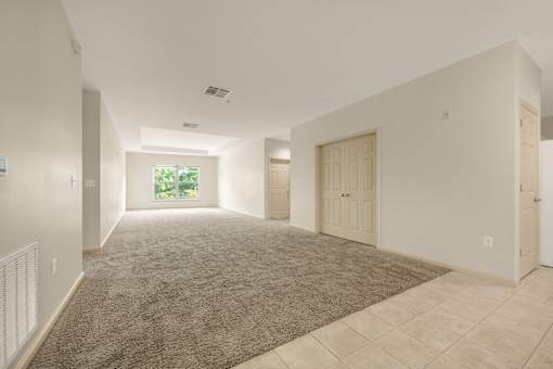 A spacious room with a carpeted floor and tiled walls.